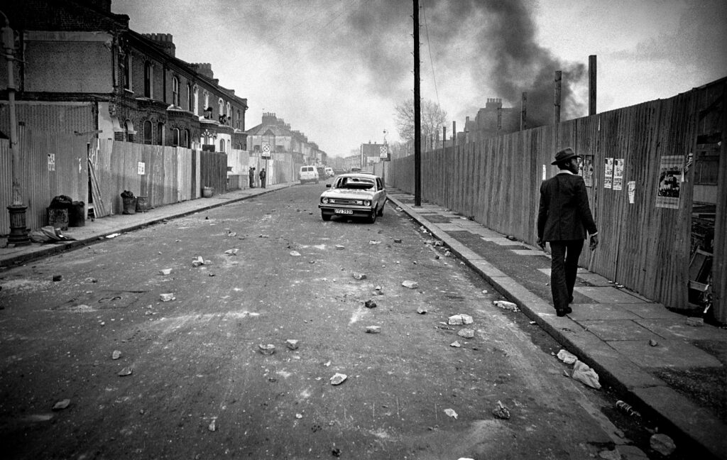 Rioters pause temporarily to allow a local back to his home