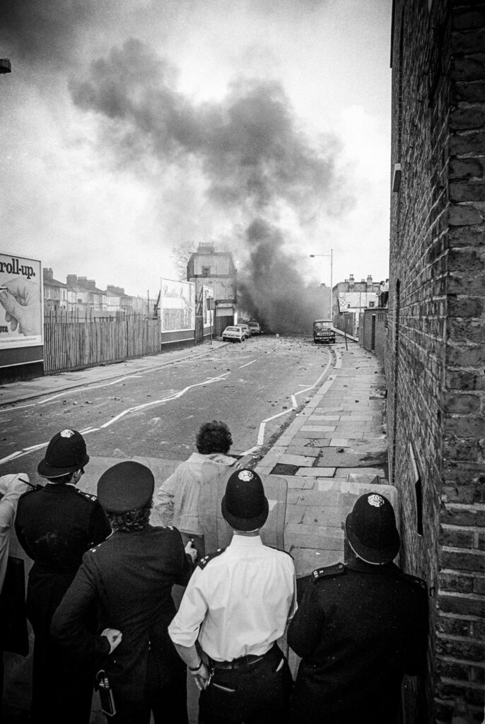 Police look on as another car explodes. Railton Rd